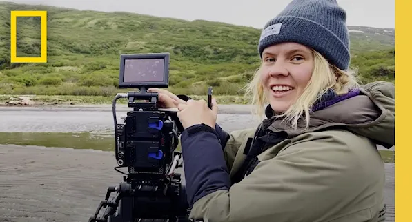 Sophie Darlington looking through a camera lens